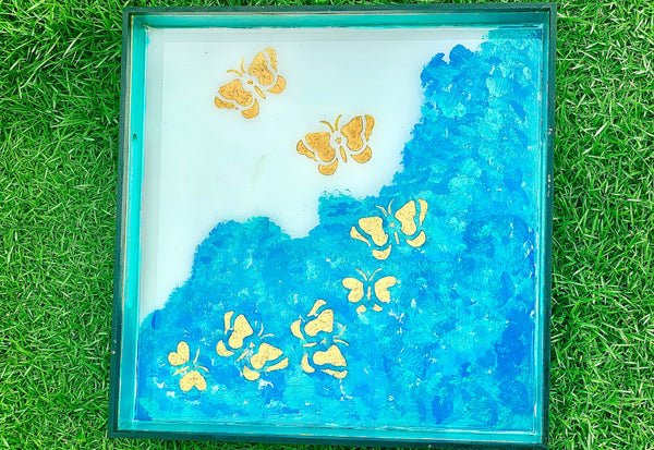 Golden butterflies in blue waves tray